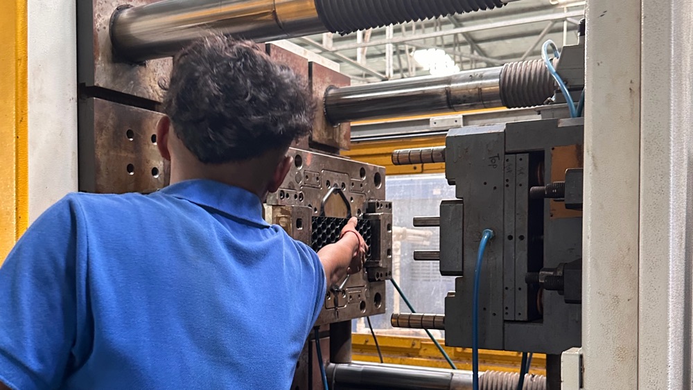 Operator working at an open mould on an injection moulding machine